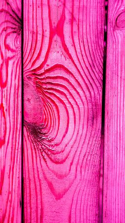 close up of crimson wooden planks with round knots and lines around them as waves on sea. abstract lines on wood as natural background. natural wooden texture of fence, wall or floor as backgroundの写真素材