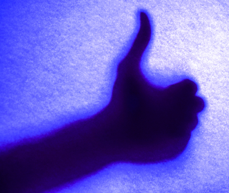 blue light silhoette of like hand in mystery light. colorful silhouettes of hands young woman and a...