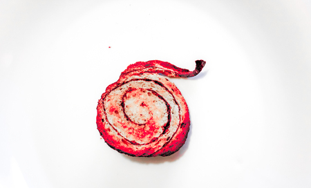 light yellow sweet round cinnamon bun with dark spiral and texture of a porous dough inside with dark brown crispy crust. bun as sweet fresh snail on white backgroundの写真素材