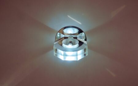 Circle big chandelier with crystals, round mirror and lamps which made reflection on ceiling as star light. Beautiful luxury chandelier with briliants and light insideの写真素材