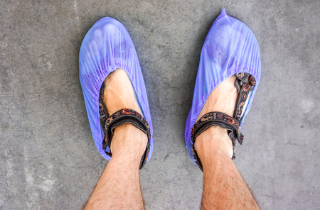 colorful hospital clean overshoes on mans legs in sandalsの写真素材
