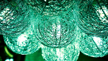 small lamps inside green lightning balls. modern art luxury chandelier made with balls with lamp inside every one, which connect to beautiful flower. Lighting ball hanging from ceiling on backgroundの写真素材