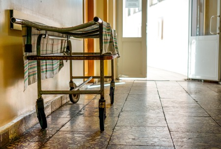 Wheelchair wait for visitors and ill people in corridor of city hospital. Wheelchair as symbol of last way. Social hospital for poor man. Interior of old city municipal hospital.の写真素材