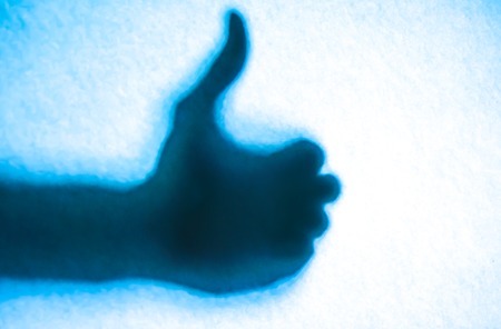 Silhouettes of hands young woman and a man with shape of thumbs for great and best concept.の写真素材