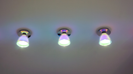 Small geometrical lamps with light inside on ceilling. Warm light from a lamp on the ceiling.
