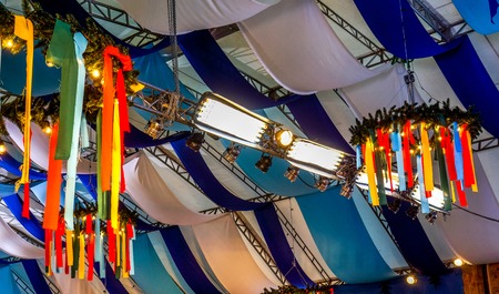 colorful ribbon decoration on ceiling at beer festival. typical decoration at a oktoberfest. ribbons rainbow as ceiling decoration in openspace or bar or restaurantの写真素材