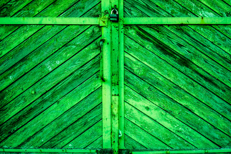 Bright green emerald diagonal old wooden planks with parts of cracked paint, knots and spots as wooden texture. vintage wooden planks as backgroundの写真素材
