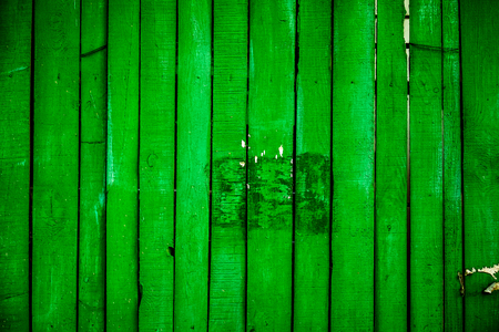 fence of green emerald vertical old wooden planks with parts of cracked paint and natural wooden texture with letters exit on it, knots and spots. vintage wooden planks as backgroundの写真素材