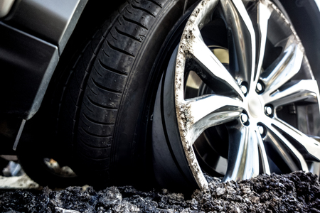 the car's drive burrowed into the asphalt as a result of car crash top view. silver luxury car wheel...