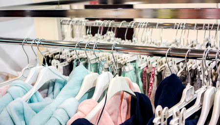 silver diagonal racks with summer colorful shirts with square pattern on white shopping racks on...