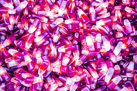 background of many small cola bottle candies as backgroundの写真素材