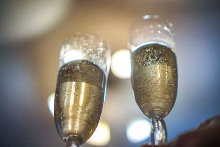 two long glass glasses with champaign and bubbles insideの写真素材
