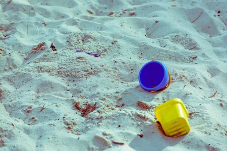 sunny sand beach with few plastic kids toysの写真素材