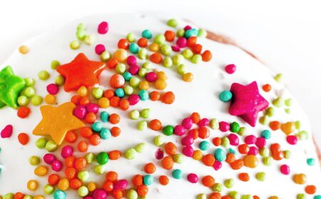 many small sugar colorful drops on white sweet cake topの写真素材
