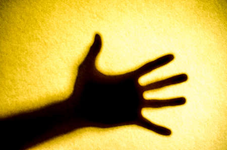 Shadow hands of the Man behind frosted glass.の写真素材