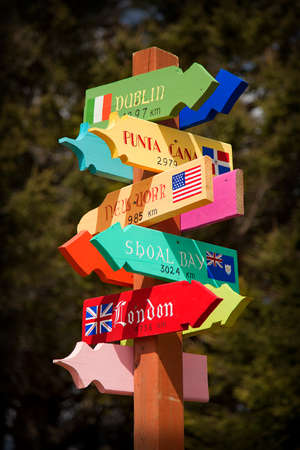 Colorful post indicating directions to multiple countries. Isolated on a blurry background.の写真素材