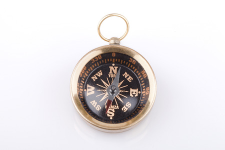 Brass compass on a white surface. Compass isolated on white background.の写真素材