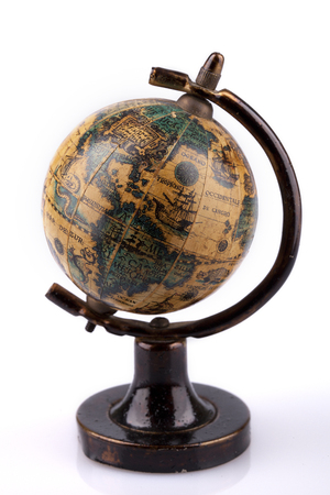 Vintage world globe on a wooden stand on a white surface. Antique world globe isolated on white background.の写真素材