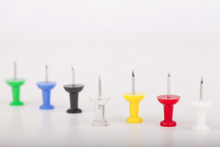 Colorful pushpins on a white surface. Pushpins isolated on white background.の写真素材