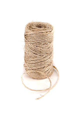 Spool of twine on a white surface. Roll of twine isolated on white background.