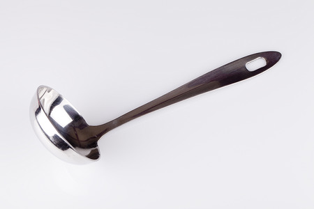 Metal soup ladle on a white surface. Soup ladle isolated on white background.の写真素材