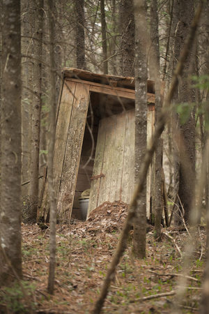 Old abandoned wooden outhouse in the woods.の写真素材