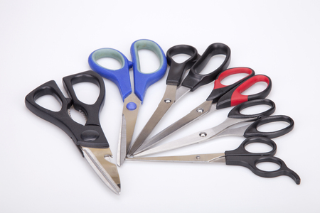 Bunch of scissors of different style and size on a white surface. Scissors isolated on white background.の写真素材