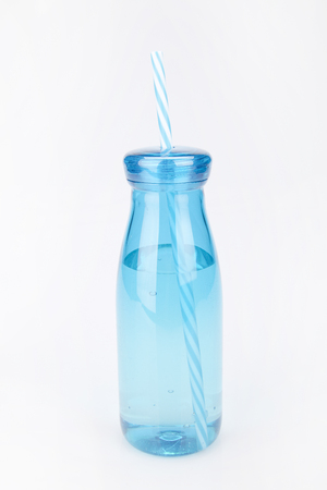 Blue plastic tumbler on a white surface. Tumbler isolated on white background.の写真素材