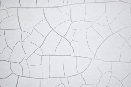 White old crackled paint on a wall. Crackle texture. Crackling abstract background.