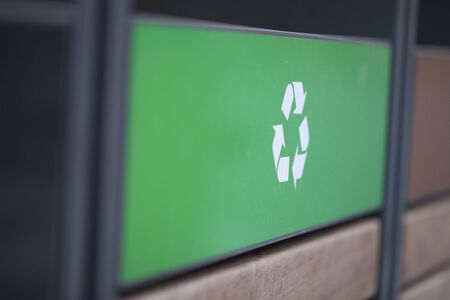 Recycling logo on a green panel shot at an angle. Recycling logo at an angle perspective. Shallow depth of field.の写真素材