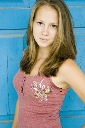 Blonde teen girl on blue backgroundの写真素材