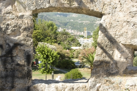 A window in the ramparts allows to see the hills around the city of Budva, Montenegro.の写真素材