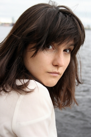 Portrait of beautiful serious woman with 	disorder hair on water backgroundの写真素材