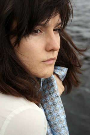 Portrait of beautiful serious woman with 	scarf on water background.の写真素材