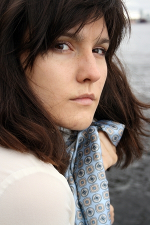 Portrait of beautiful serious woman with 	scarf on water background.の写真素材