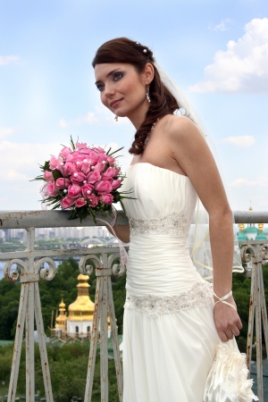 A lovely bride with bouquet from roses outdoor.の写真素材