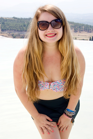 Beautiful blonde woman in a swimsuit, sunglasses and shorts in Pamukkale, Turkeyの写真素材