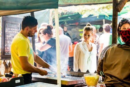 Johannesburg, South Africa - May 24, 2015: Male chef vendor working a BBQ Grill at hamburger stall at farmer's marketのeditorial素材
