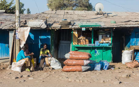 Addis Ababa, Ethiopia, January 30, 2014, People sitting outside small colorful grocery shops on a...