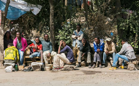 Addis Ababa, Ethiopia, January 30, 2014, Small group of African men waiting for a bus on the side of a quiet suburban streetのeditorial素材