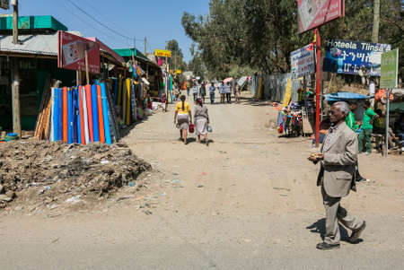 Addis Ababa, Ethiopia, January 30, 2014, African man walking past a busy market place on a side streetのeditorial素材