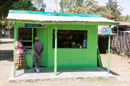 Addis Ababa, Ethiopia, January 30, 2014, Two people making a purchase from a small shop on the side of the roadのeditorial素材