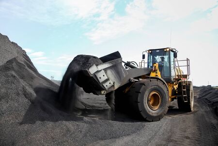 Wheel Loader scooping Manganese ore for processing の写真素材