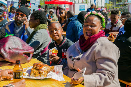 Soweto, South Africa - September 8, 2018: Diverse African people at a bread based street food...