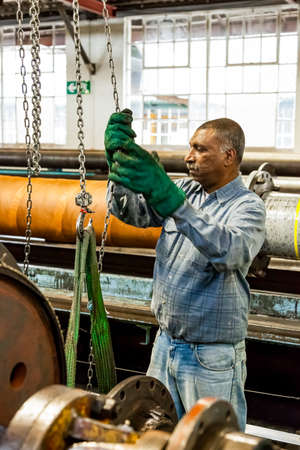 Johannesburg, South Africa - October 19, 2012: Diverse workers inside a rubber and pipe fabrication...