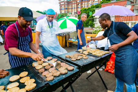Johannesburg, South Africa - March 24, 2018: Diverse men preparing food on bbq grill for community outreach volunteer programのeditorial素材