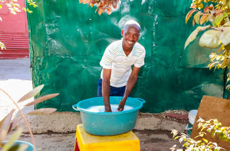 Johannesburg, South Africa, September 11, 2011, Male teacher washing clothes at Creche Daycare Preschool in suburban Sowetoのeditorial素材