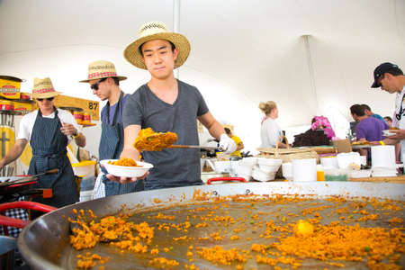 Johannesburg, South Africa - November 9 2013: Male Chef making and serving Paella Seafood take-away meals at food festival vendor stallのeditorial素材