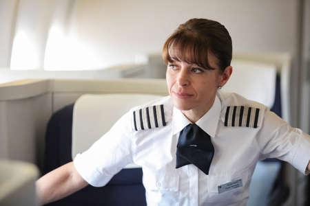 Johannesburg, South Africa - May 08 2012: British Airways Middle Aged Female Captain Pilot in an Airplane cabinのeditorial素材