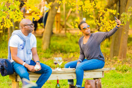 Johannesburg, South Africa - May 12 2018: African couple taking a selfie photo at food and wine...
